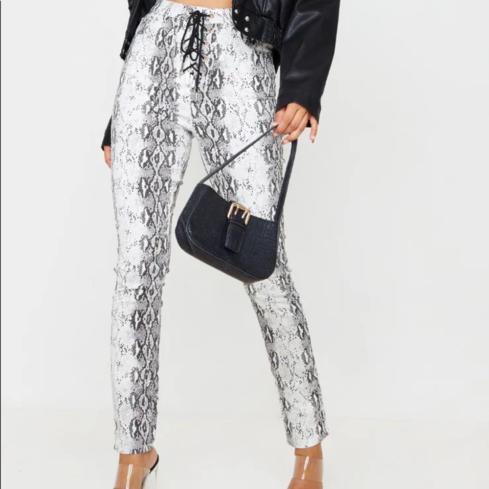 Snake print lace up skinny jeans.